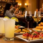 Olive Garden happy hour drinks and appetizers on a table in a cozy bar setting.